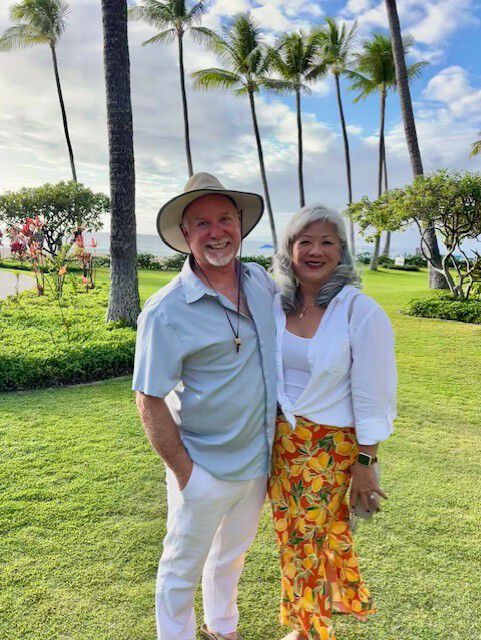 a man and a woman in front of palm trees
